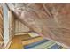 Unfinished attic with exposed framing, vapor barrier, and a small window at 2513 Myrtle Ln, Hillsborough, NC 27278