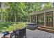 Private backyard featuring a paver patio, hot tub, fire pit, and screened-in porch with wooded backdrop at 2513 Myrtle Ln, Hillsborough, NC 27278