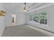 Neutral bedroom featuring tray ceiling, large windows, and an adjacent room at 2513 Myrtle Ln, Hillsborough, NC 27278