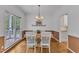 Dining room with wood floors, large windows, wainscoting and a view to the outdoor patio at 2513 Myrtle Ln, Hillsborough, NC 27278