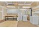 A well-lit garage featuring white cabinets, a workbench, and laundry appliances for convenience at 2513 Myrtle Ln, Hillsborough, NC 27278