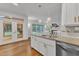 Bright kitchen island with granite countertops and white cabinets with views of adjacent living space at 2513 Myrtle Ln, Hillsborough, NC 27278
