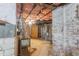 A look at the unfinished basement, featuring brick walls and visible insulation. The water heater is visible at 2515 W Club Blvd, Durham, NC 27705
