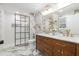 Bathroom featuring double vanity sinks, marble tile, and a glass-enclosed shower with gold fixtures at 2515 W Club Blvd, Durham, NC 27705