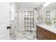 Elegant bathroom featuring marble tile, glass enclosed shower, and a wooden vanity with modern fixtures at 2515 W Club Blvd, Durham, NC 27705