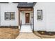 Charming front entrance with a wood door, white brick, and landscaped flower beds at 2515 W Club Blvd, Durham, NC 27705