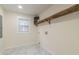 Laundry room with white walls, grey marble floor, a window, and a wooden shelf on the wall at 2515 W Club Blvd, Durham, NC 27705
