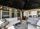 The covered back porch features white couches, pendant lighting, and plenty of space for relaxing or entertaining at 2605 Mcdougall Dr, Burlington, NC 27217