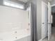 Clean bathroom with a white tiled shower-tub combination, window, and neutral wall color at 2605 Mcdougall Dr, Burlington, NC 27217