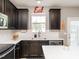 Well-lit kitchen featuring dark cabinets, white countertops and subway tile, plus stainless steel appliances at 2605 Mcdougall Dr, Burlington, NC 27217