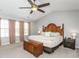 Spacious main bedroom features a ceiling fan, a large window and decorative brown curtains at 2605 Mcdougall Dr, Burlington, NC 27217