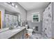 Cozy bathroom featuring a granite countertop, large mirror, and unique patterned shower curtain at 2824 Blanche Dr, Burlington, NC 27215