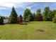 Fenced in backyard with a play-set and mature landscaping at 310 Seymour Pl, Cary, NC 27519