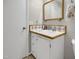 Bathroom featuring a vanity with white cabinets, patterned tile, and a framed mirror at 312 Green St, Sanford, NC 27330