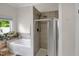 Bright bathroom features a shower, soaking tub and a large window at 312 Green St, Sanford, NC 27330
