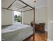 Bedroom with a four-poster bed, hardwood floors, and natural light, offering a tranquil retreat at 312 Green St, Sanford, NC 27330