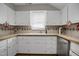 Kitchen with white cabinets and countertops, stainless steel appliances, and a window at 312 Green St, Sanford, NC 27330
