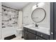 Elegant bathroom with a shower-tub combo, modern vanity, and stylish round mirror at 320 W Martin St # 205, Raleigh, NC 27601