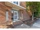 Brick building entrance with glass door and canopy, and well-maintained landscaping at 320 W Martin St # 205, Raleigh, NC 27601