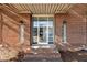 A close-up of the brick building entrance featuring a glass door and a protective canopy at 320 W Martin St # 205, Raleigh, NC 27601