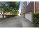 Exterior view of a brick building with garage doors and lush greenery at 320 W Martin St # 205, Raleigh, NC 27601