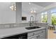 Modern kitchen island featuring a sink, dishwasher, and stylish cabinetry at 320 W Martin St # 205, Raleigh, NC 27601