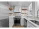 Modern kitchen with stainless steel appliances, white cabinets, and open shelving at 320 W Martin St # 205, Raleigh, NC 27601