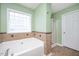 Bright bathroom features a glass block window above a large tub, and a glass doored shower stall at 3566 Sunbright Ln, Raleigh, NC 27610