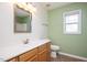 Neutral-colored bathroom featuring a wood vanity, and a large mirror at 3566 Sunbright Ln, Raleigh, NC 27610
