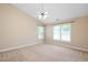 Spacious bedroom with carpet flooring, a ceiling fan, and plenty of natural light from large windows at 3566 Sunbright Ln, Raleigh, NC 27610