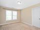 Neutral carpeted bedroom with bright window and a white door at 3566 Sunbright Ln, Raleigh, NC 27610