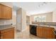 Bright kitchen with wood cabinets, black appliances, and a connecting dining area at 3566 Sunbright Ln, Raleigh, NC 27610