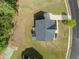 An aerial view of a home with a gray roof and lush green lawn, showcasing its yard and surrounding area at 386 The Parks Dr, Pittsboro, NC 27312