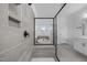 Modern bathroom featuring a glass enclosed shower with a tub, and gray tiling at 386 The Parks Dr, Pittsboro, NC 27312