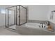 Modern bathroom featuring a glass enclosed shower with a tub, and gray tiling at 386 The Parks Dr, Pittsboro, NC 27312