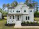 Charming two-story white home featuring a welcoming front porch, manicured lawn, and gray metal roof at 386 The Parks Dr, Pittsboro, NC 27312