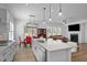 Open-concept kitchen with island seating, stainless appliances, and seamless flow into dining/living areas at 386 The Parks Dr, Pittsboro, NC 27312