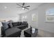A spacious living room with a large sectional, a ceiling fan, and plenty of natural light at 386 The Parks Dr, Pittsboro, NC 27312