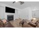 Cozy living room with fireplace, mounted TV, and comfortable leather seating with wood flooring at 386 The Parks Dr, Pittsboro, NC 27312