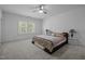 Spacious primary bedroom with carpet, large windows, ceiling fan, and decorative lamps at 386 The Parks Dr, Pittsboro, NC 27312