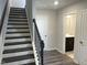 Entryway staircase with black and white railings and gray wood floors at 4004 Silver Oak Ln # 97, Durham, NC 27703