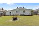 Exterior backyard view showing the home, a fire pit area, and a spacious grassy area at 404 W E St, Erwin, NC 28339