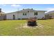 Spacious backyard featuring green grass, fire pit, and white siding on the home's exterior at 404 W E St, Erwin, NC 28339