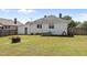 A grassy backyard with an old fire pit, white siding, and an overgrown yard at 404 W E St, Erwin, NC 28339