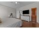 Comfortable bedroom featuring hardwood floors, a ceiling fan, and a dresser with a mounted TV at 404 W E St, Erwin, NC 28339