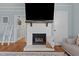 Close up of the painted brick fireplace with a mounted TV, hardwood floors, and an inviting ambiance at 404 W E St, Erwin, NC 28339