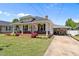 Cozy home with a brick porch, American flag, covered parking, and lush greenery at 404 W E St, Erwin, NC 28339