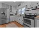 Functional kitchen featuring stainless steel appliances, white cabinetry, and a light granite countertop at 404 W E St, Erwin, NC 28339