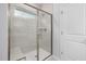 Modern walk-in shower featuring a sleek glass door, gray tiled walls, a built-in bench, and contemporary fixtures at 425 Providence Springs Ln, Fuquay Varina, NC 27526
