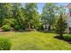 Serene backyard featuring lush landscaping, mature trees, and a hammock at 4404 Yadkin Dr, Raleigh, NC 27609